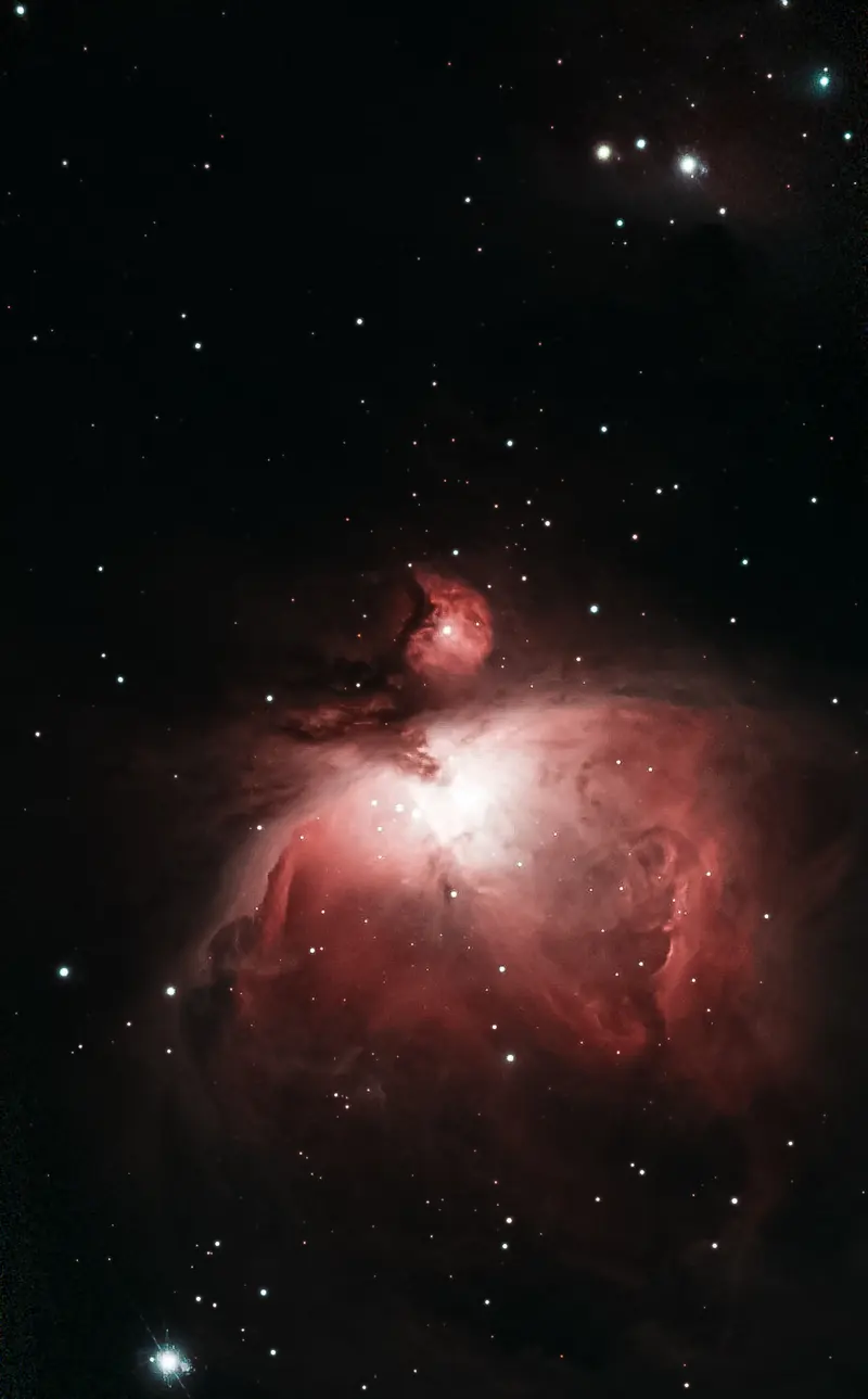 La nebulosa de Orión en tonos rojizos con las nubes de gas bien definidas