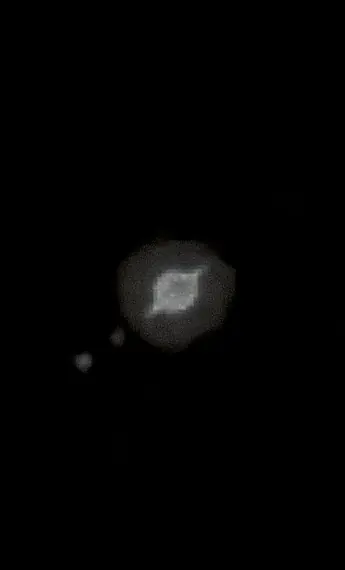 El planeta Saturno con sus anillos, pequeño sobre el fondo negro del cielo