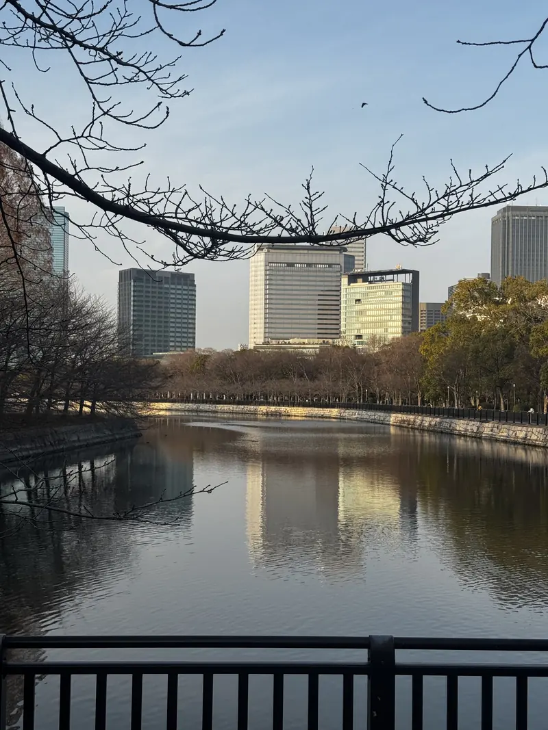 El foso del castillo de Osaka reflejando los edificios modernos de la ciudad