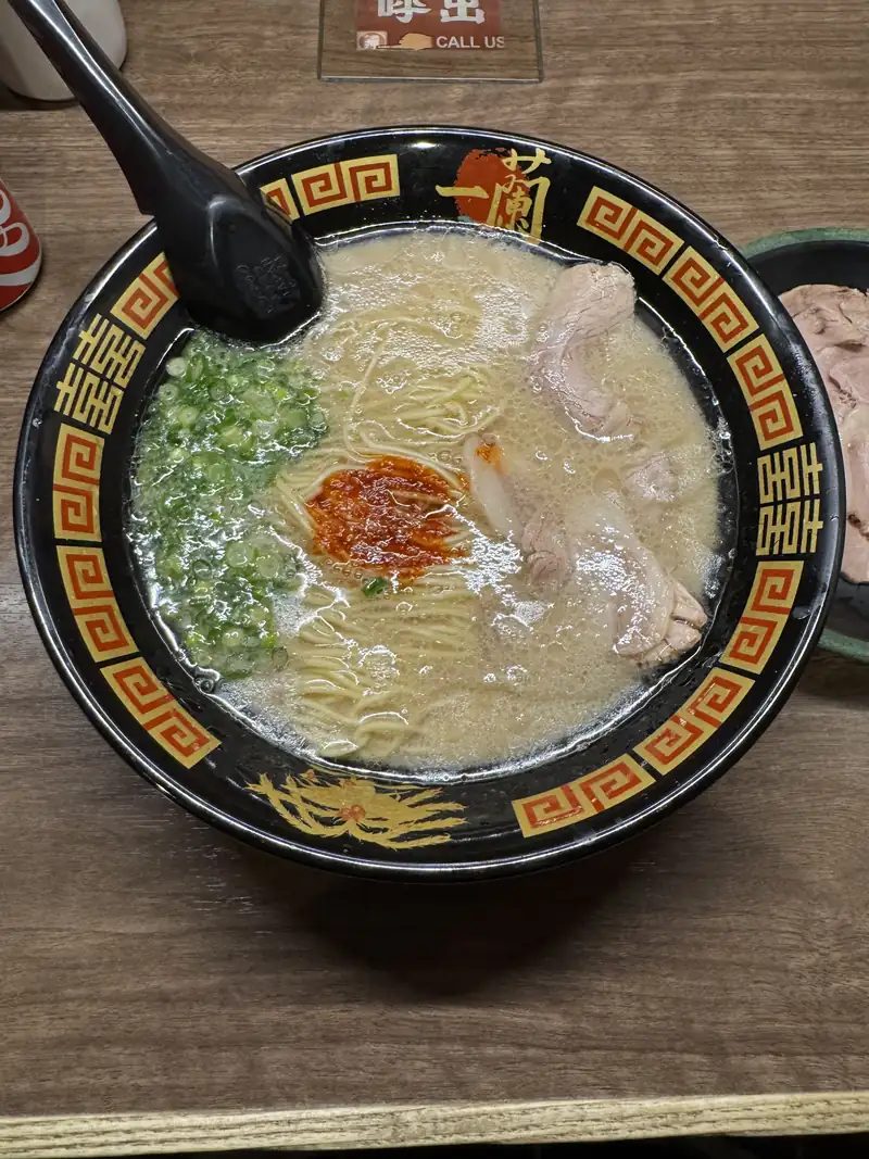 Un tazón de ramen tonkotsu con cerdo y cebollín visto desde arriba