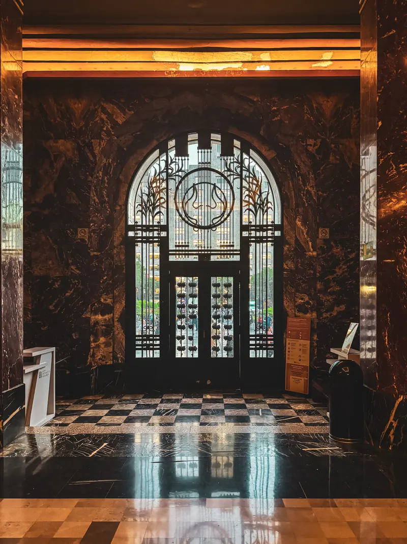 Interior art déco con puertas de vidrio emplomado, mármol y piso de ajedrez