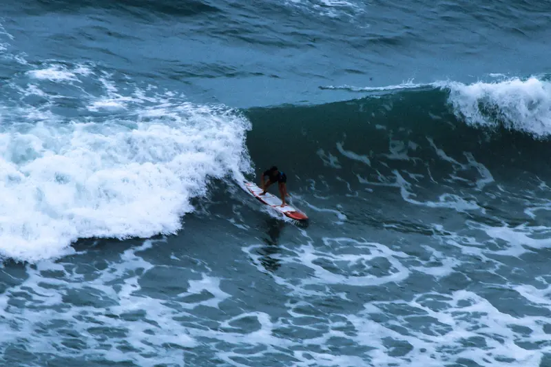 Un surfista tomando una ola que rompe en blanco